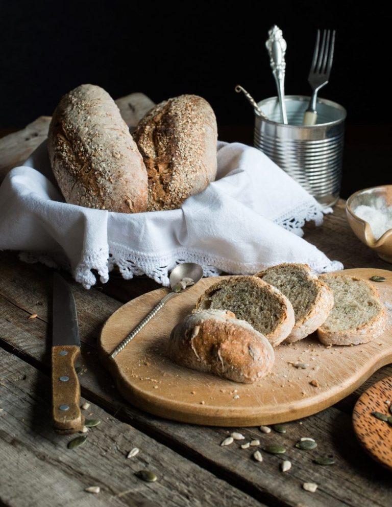 Ψωμάκια σε καλάθι και σε ξύλο κοπής