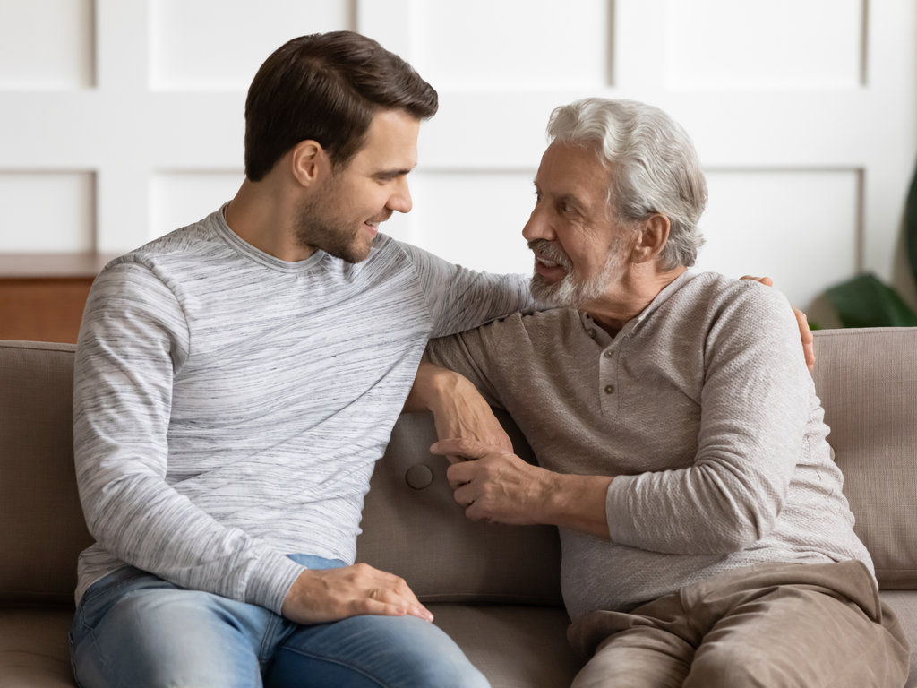 Πατέρας ηλικιωμένος και γιος τριαντάρης κάθονται στον καναπέ και μιλάνε