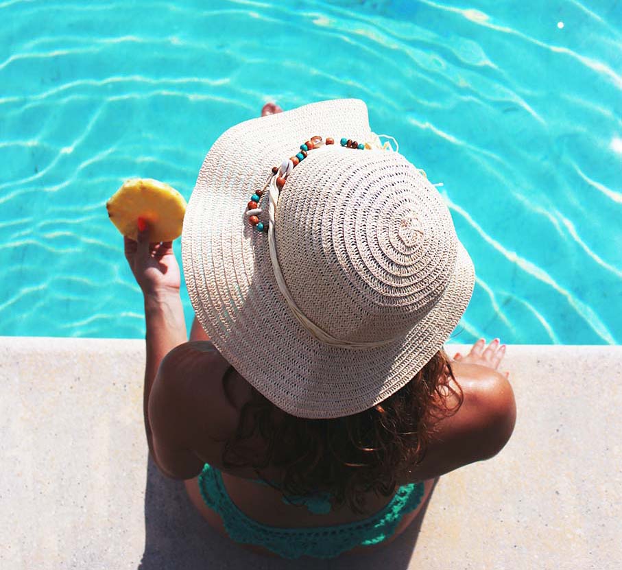 Γυναίκα δίπλα στη πισίνα με καπεέλο