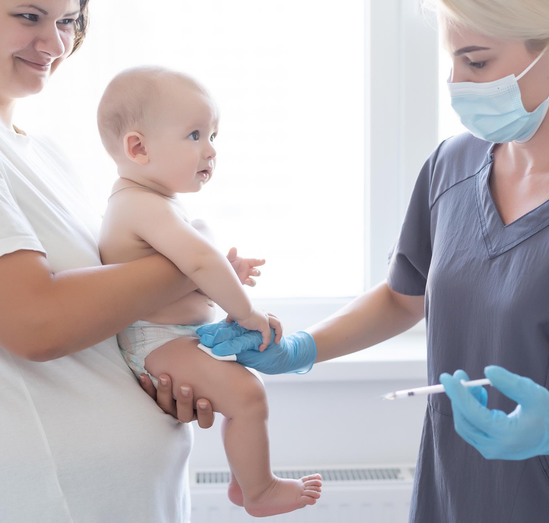 Γιατρός ετοιμάζεται να κάνει εμβόλιο σε μωράκι που το κρατά η μητέρα του ή άλλη