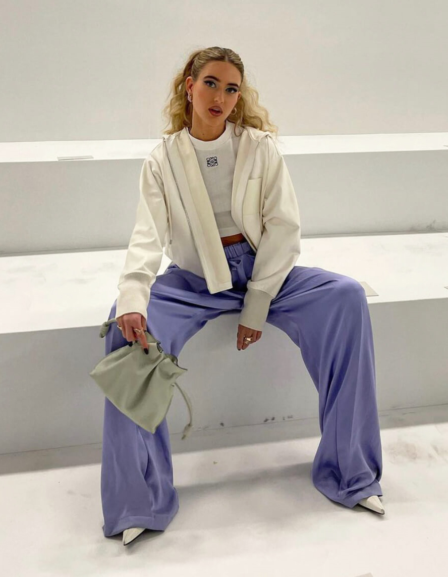 Η Emili Sindlev influencer με παντελόνι και πουλόβερ κάθεται