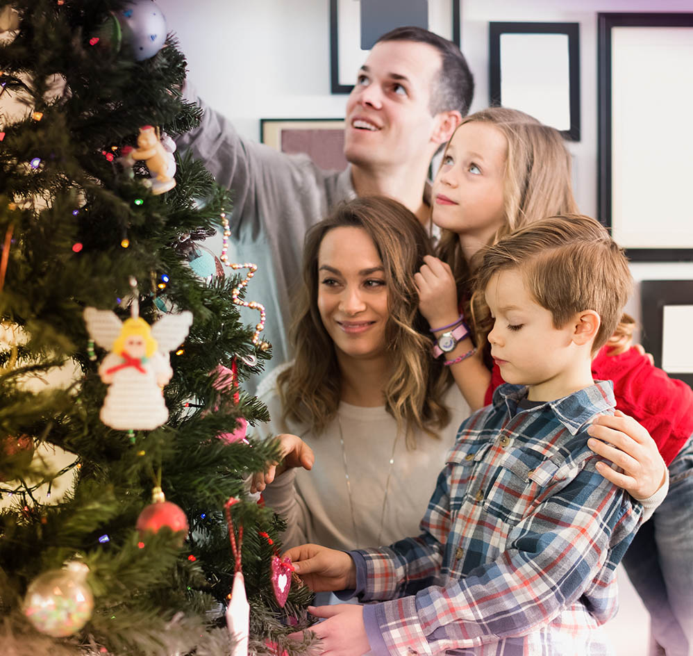 Oικογένεια με παιδιά μπροστά στο χριστουγεννιάτικο δέντρο