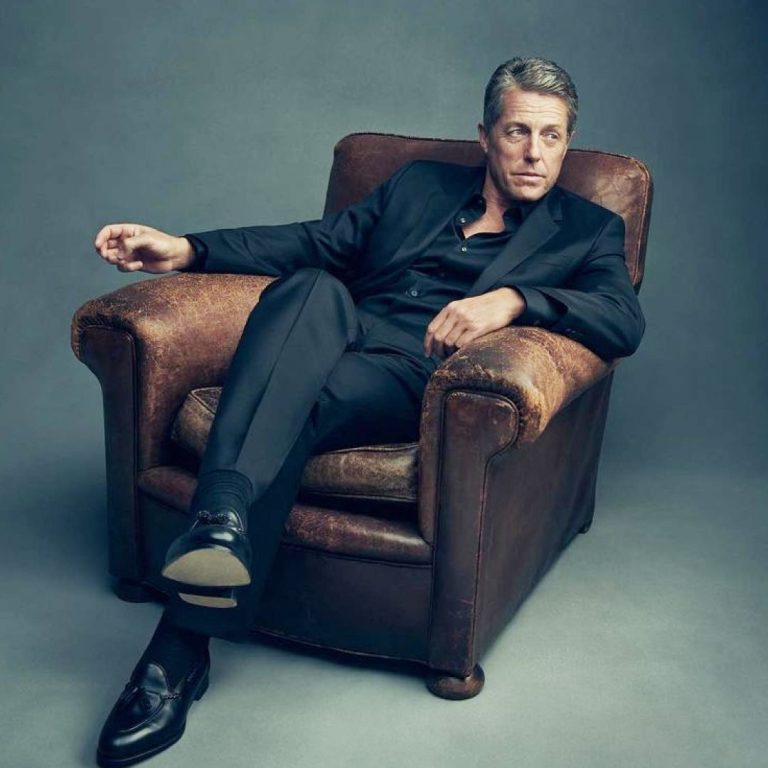 O hugh grand κάθεται σε πολυθρόνα