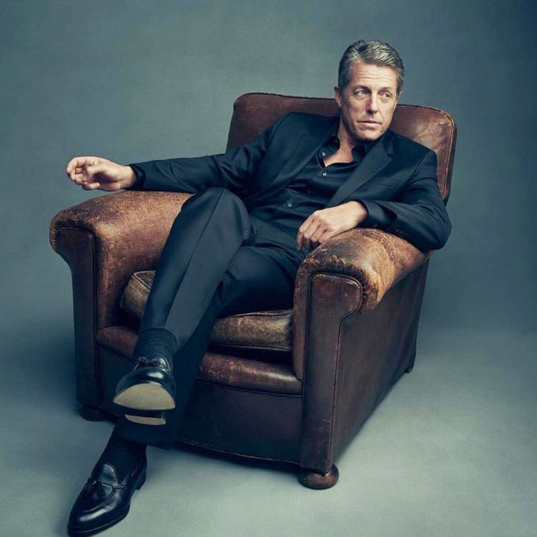 O hugh grand κάθεται σε πολυθρόνα