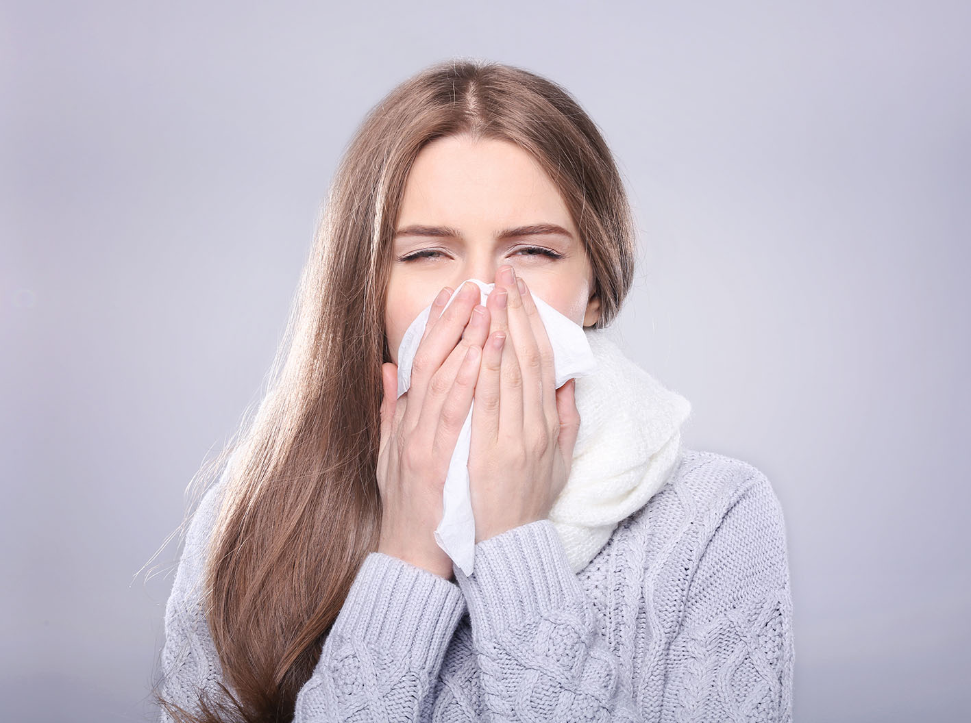 Γυναίκα άρρωστη με γρίπη φυσάει τη μύτη της