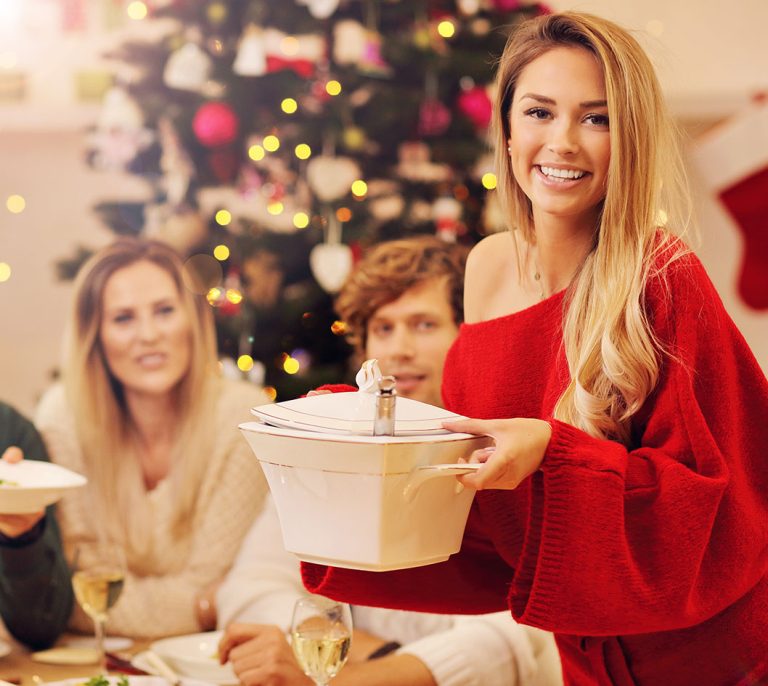 Φίλοι γύρω από χριστουγεννιάτικο τραπέζι με φαγητά