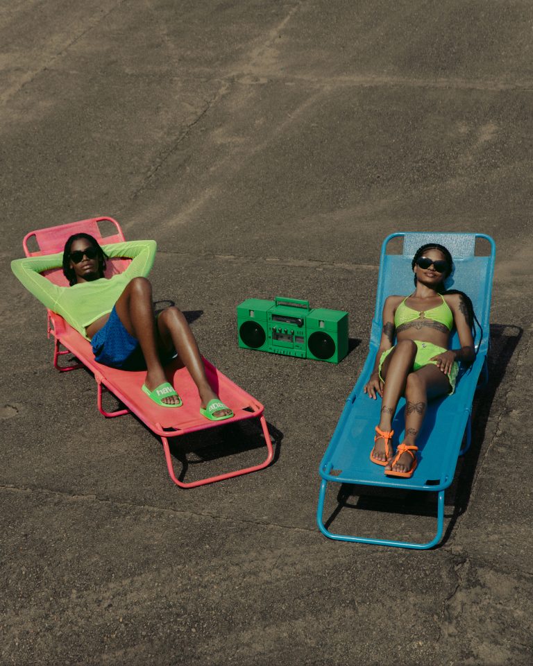 δύο μοντέλα κάνουν ηλιοθεραπέια με παντόφλες και μαγιό