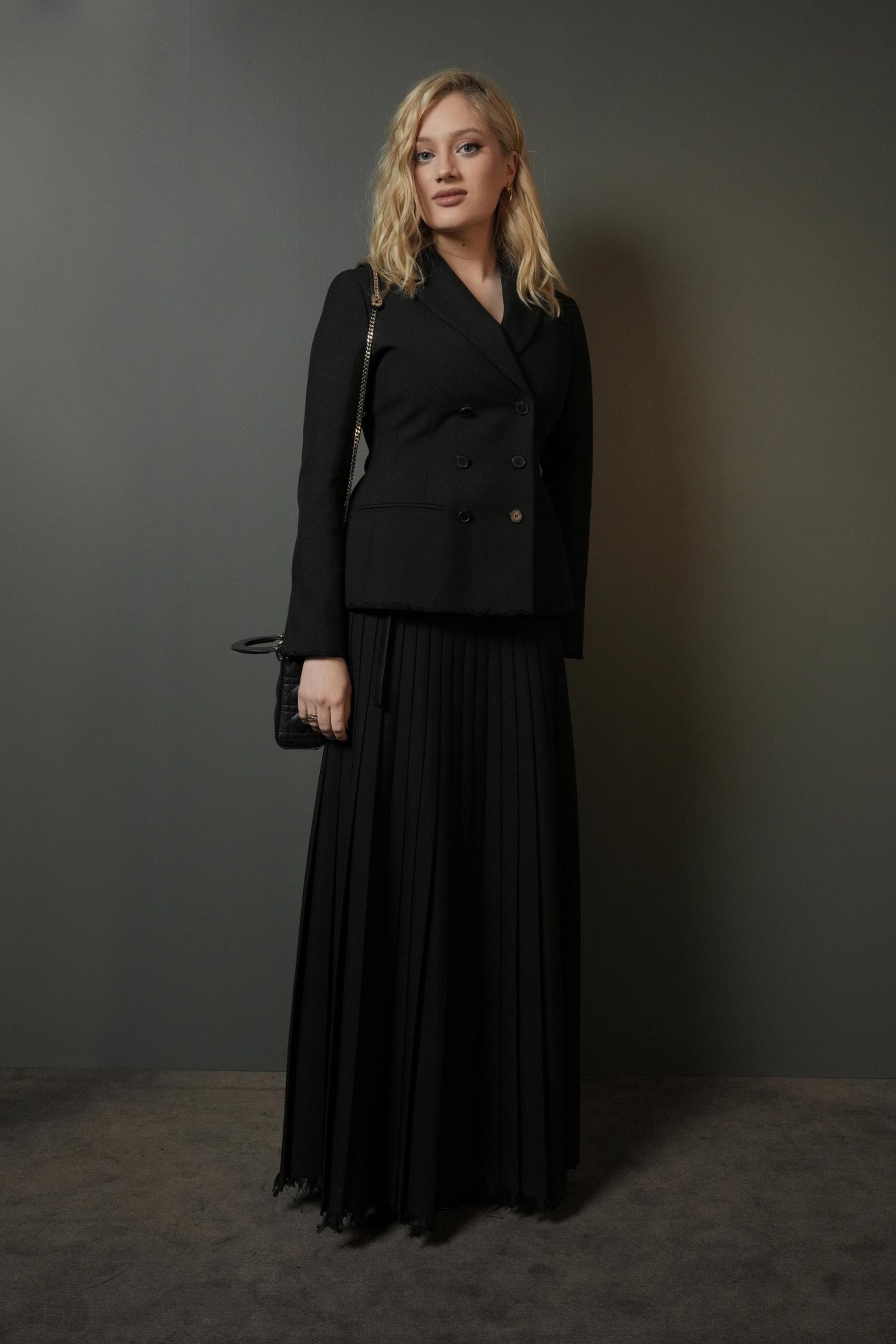 Η Nadia Tereszkiewicz φόρεσε ένα μαύρο σακάκι Dior από μαλλί και μετάξι με μαύρη πλισέ μεταξωτή φούστα.