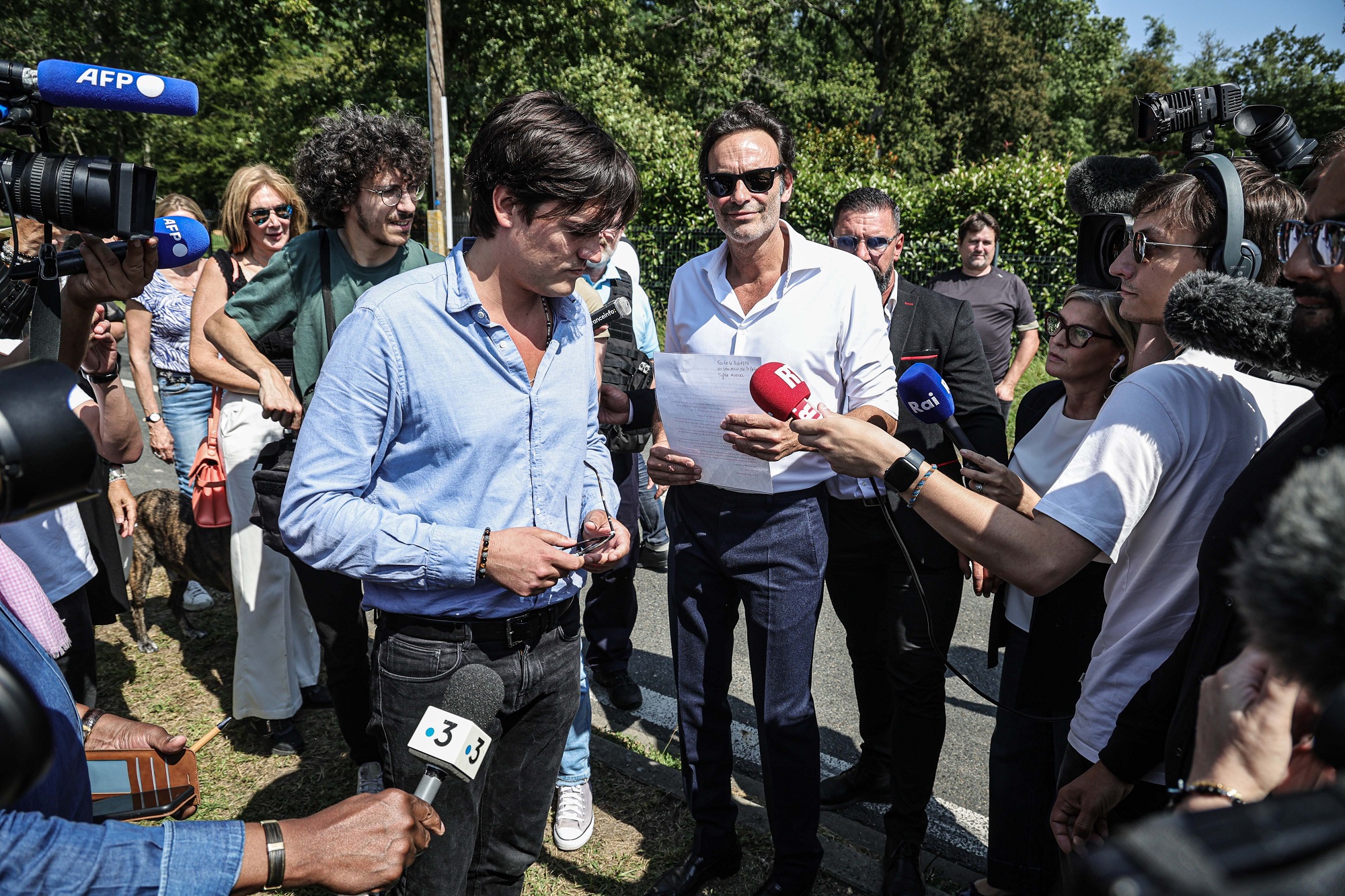 Ο Anthony Delon και ο Alain-Fabien Delon μιλούν με τους θαυμαστές που συγκεντρώθηκαν για να τιμήσουν τον πατέρα τους, στις πύλες της οικογενειακής περιουσίας στο Douchy της Γαλλίας, 24 Αυγούστου 2024.