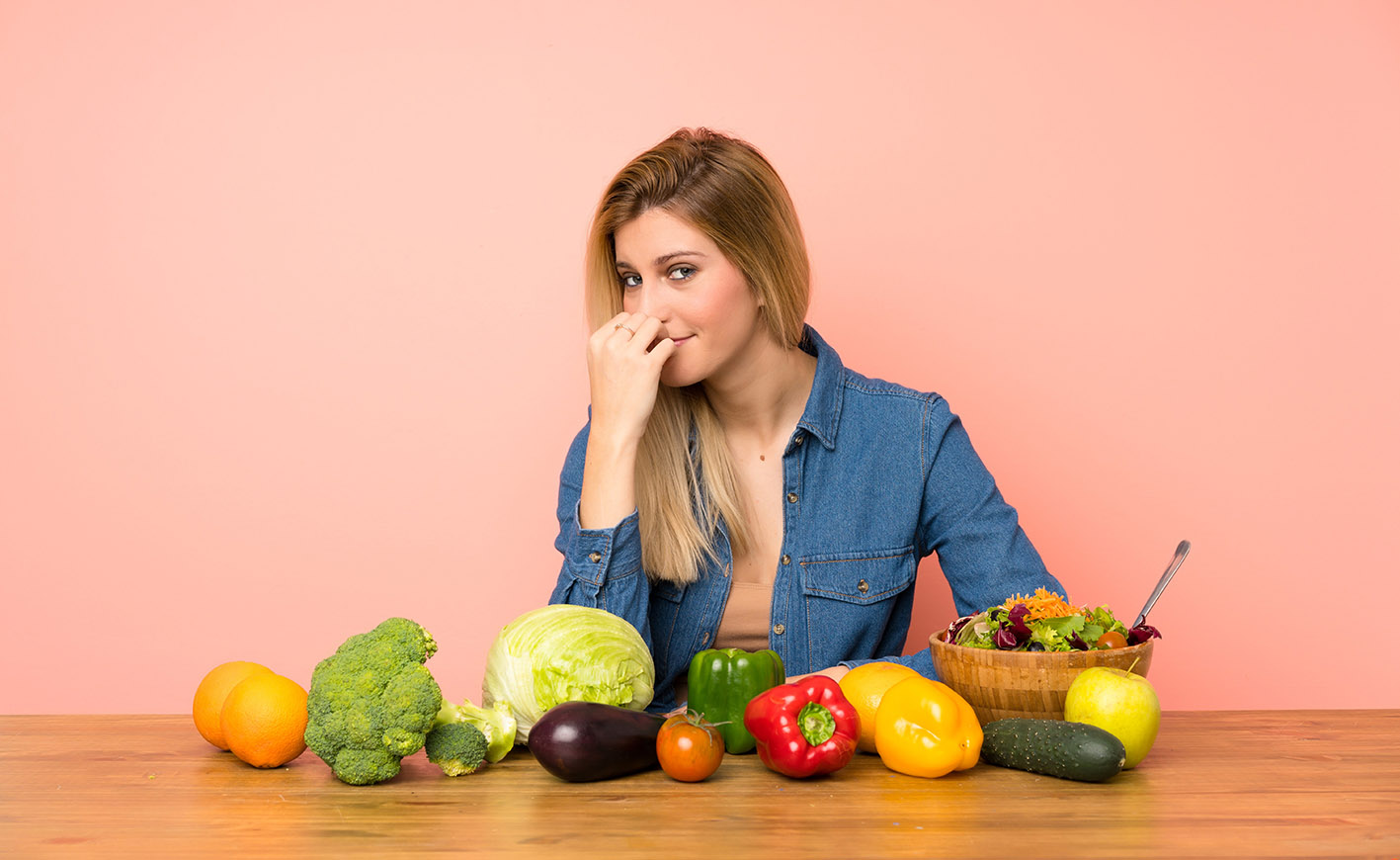Γυναίκα με λαχανικά και φρούτα αναρωτιέται τι θα φάει