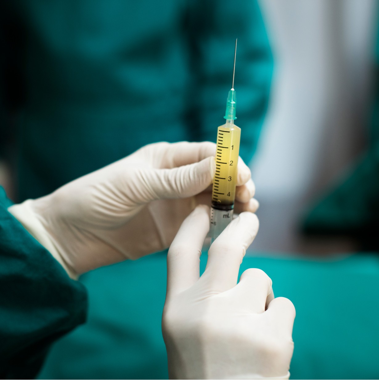 Δύο χέρια με γάντια που κρατάνε μία βελόνα με υγρό - Εμβόλιο για αρρώστιες - Πρόληψης κόνσεπτ