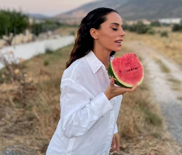 Η Μαρία Αντωνά ποζάρει λε λευκό πουκάμισο κρατώντας στο χέρι μία φέτα καρπούζι