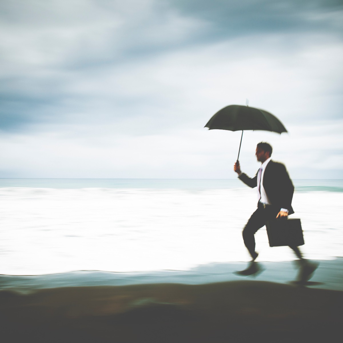 Άνδρας επαγγελματίας με ομπρέλα δίπλα στη θάλασσα