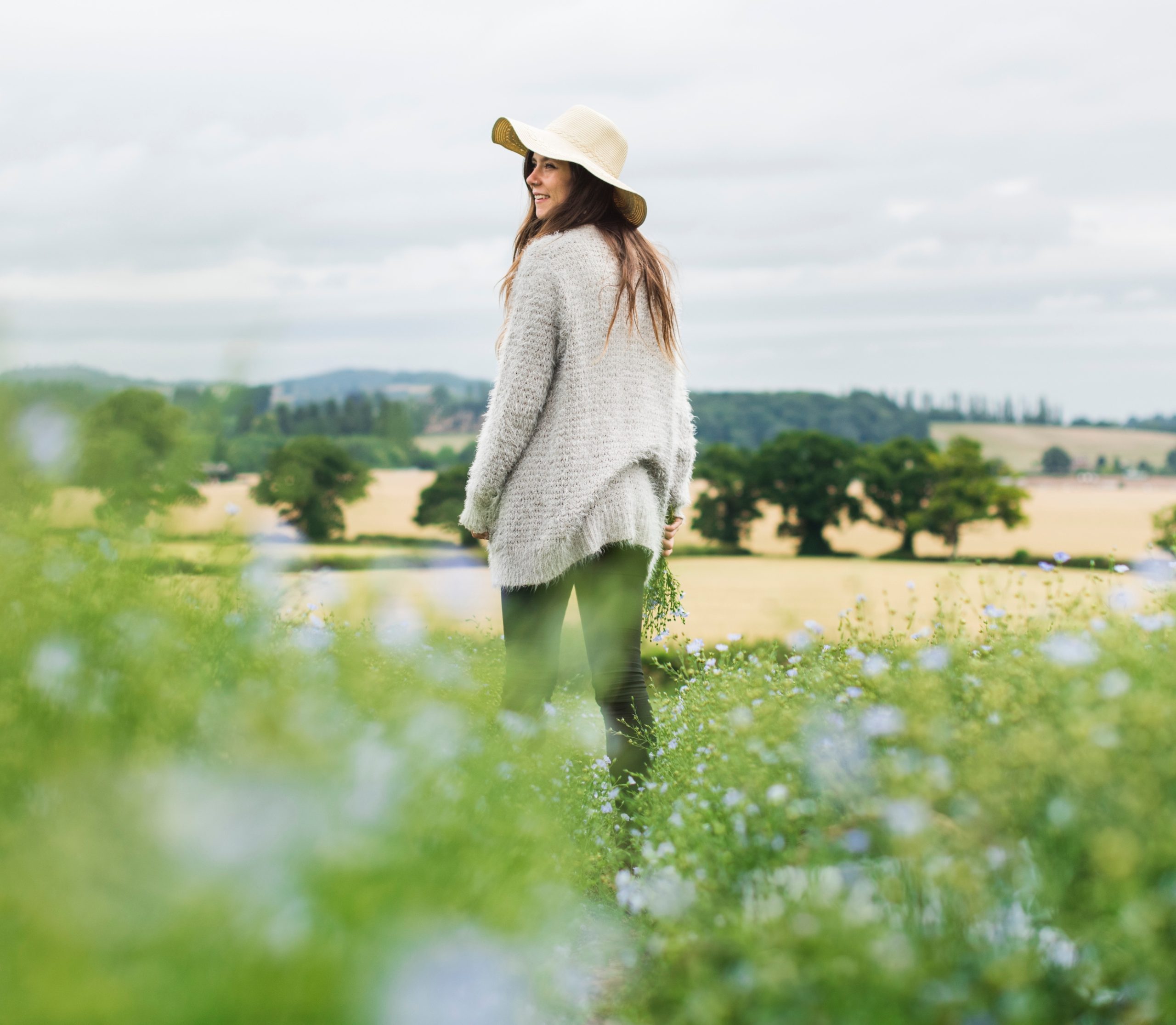 χαμογελαστή γυναίκα περπατάει σε ένα λιβάδι