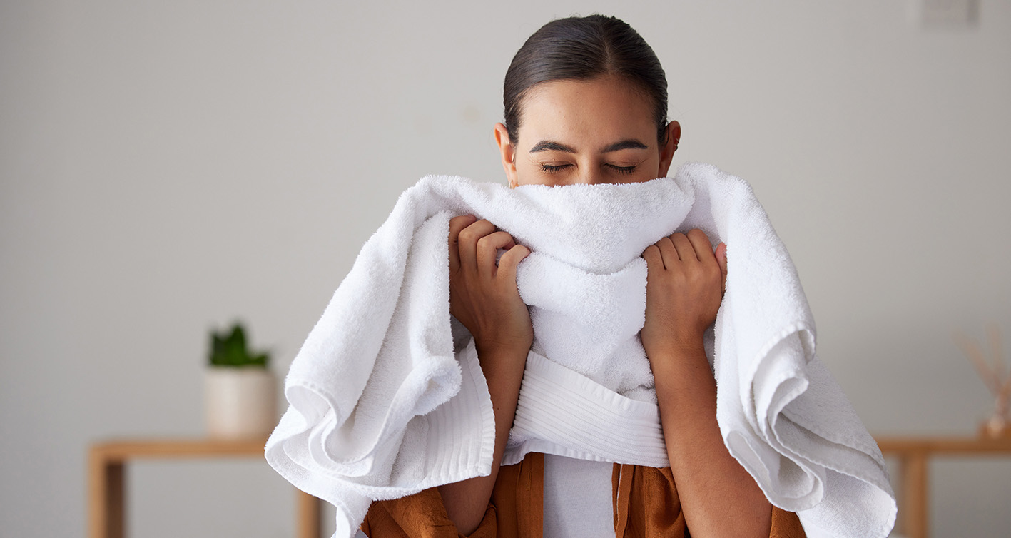 Γυναίκα σκουπίζει το πρόσωπο με πετσέτα