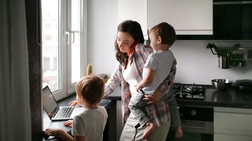 Γυναίκα μαμά με παιδιά στην αγκαλιά στο σπίτι