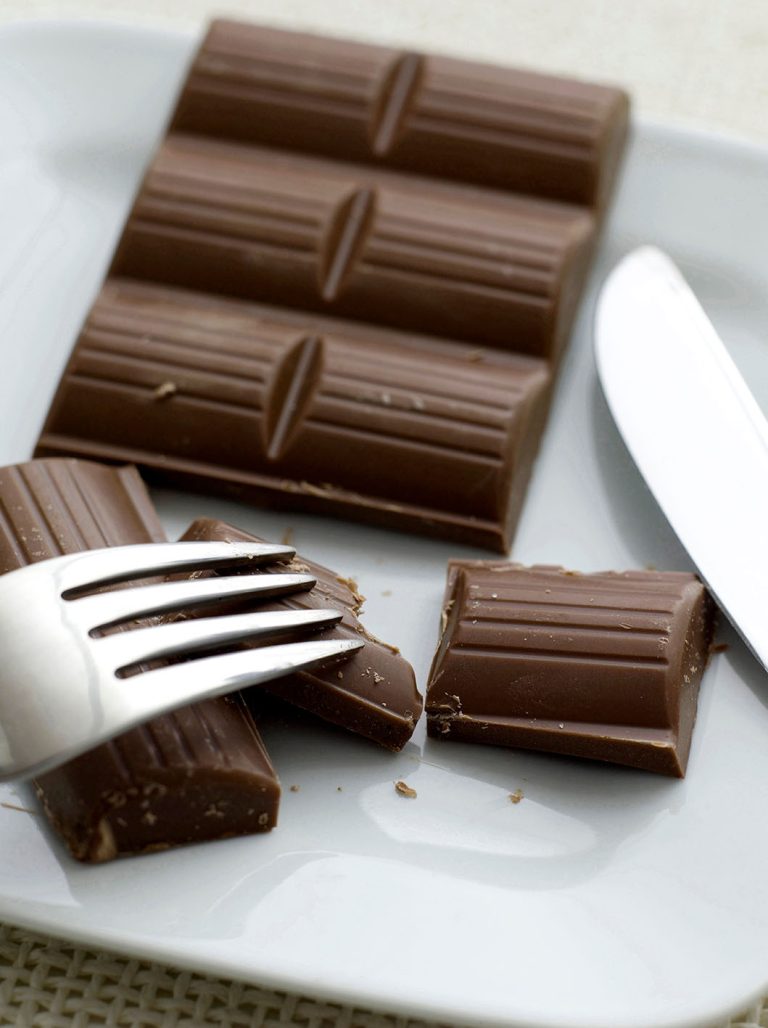 Σοκολάτα σε κομμάτια σε πιάτο με μαχαιροπήρουνο