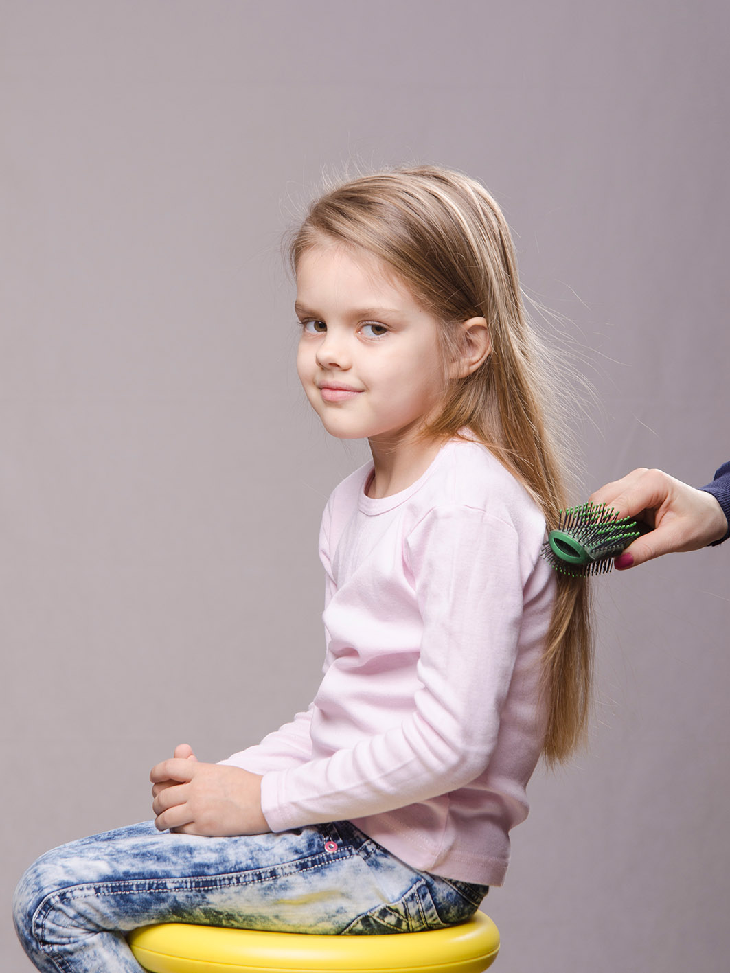 Κορίτσι κάθεται να της φτιάξουν τα μαλλιά