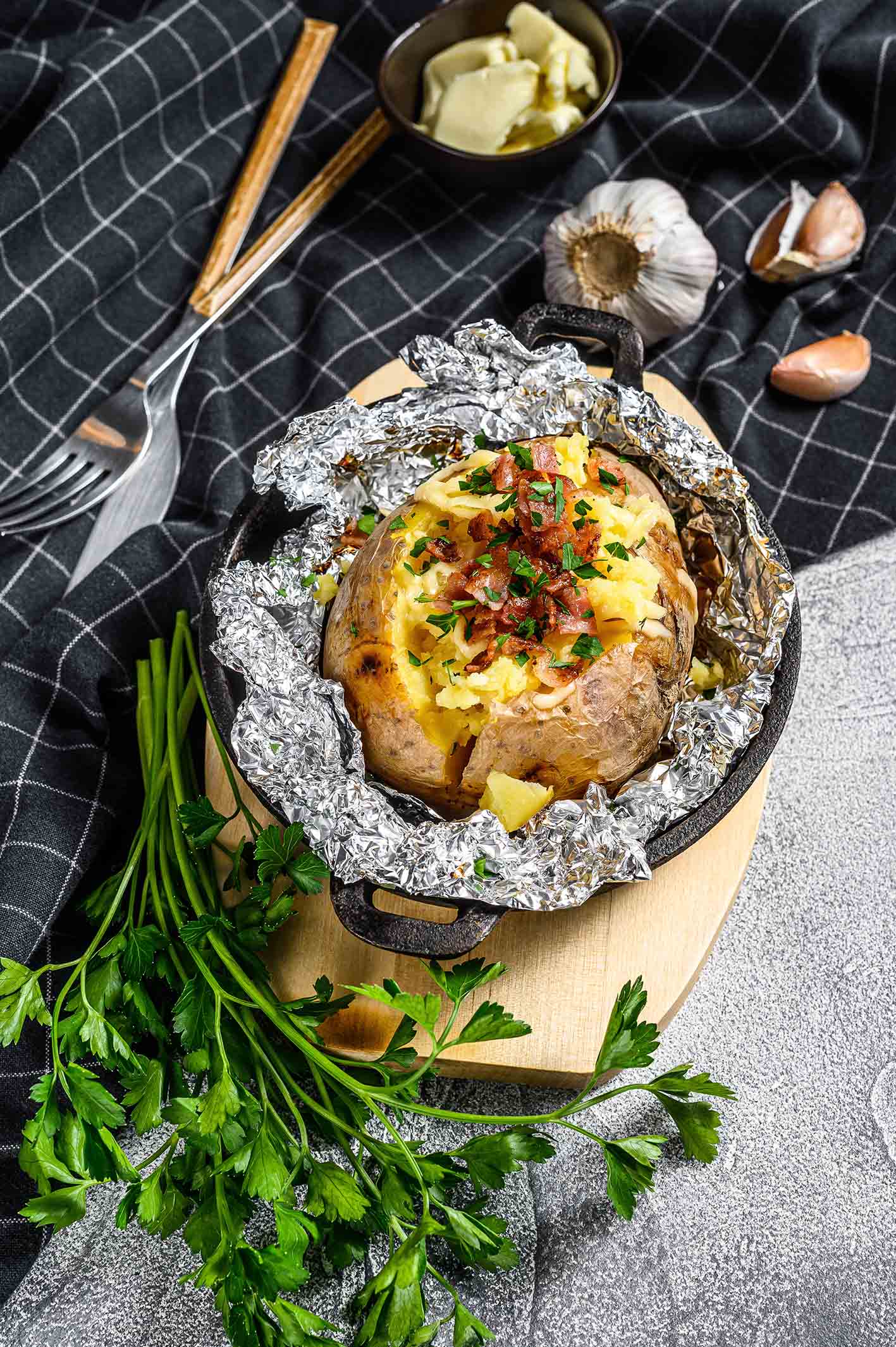 Πατάτα φούρνου γεμιστή με τυρί μέσα σε αλουμινόχαρτο.