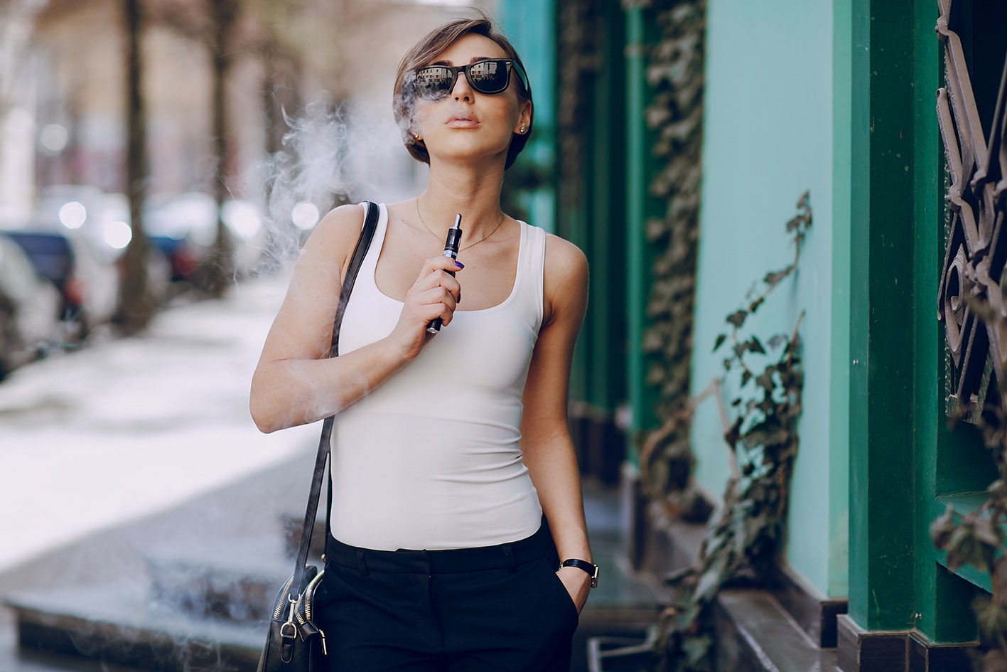 Γυναίκα με ηλεκτρονικό τσιγάρο περπατά στο δρόμο