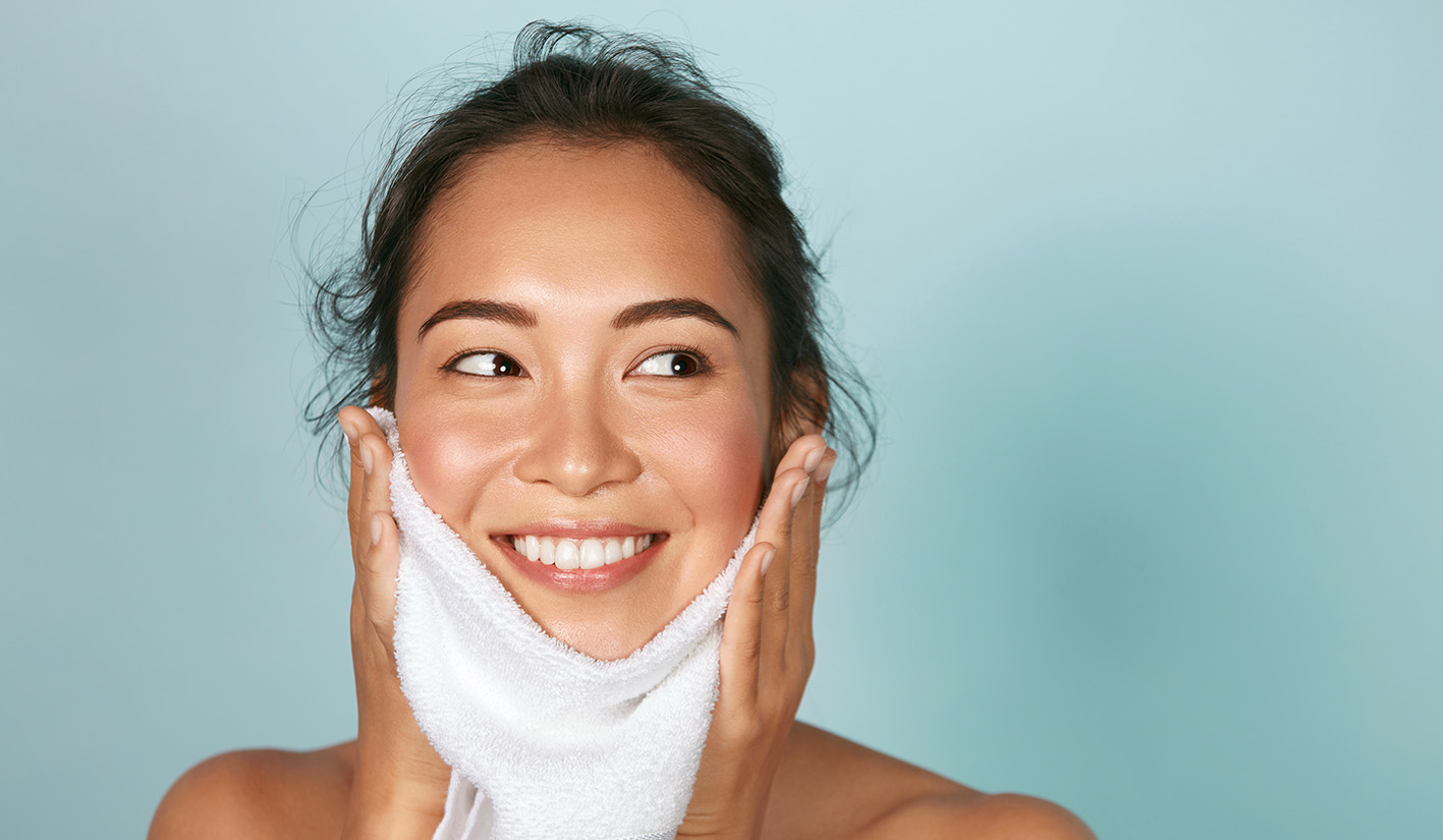 Γυναίκα σκουπίζει το πρόσωπο με πετσέτα