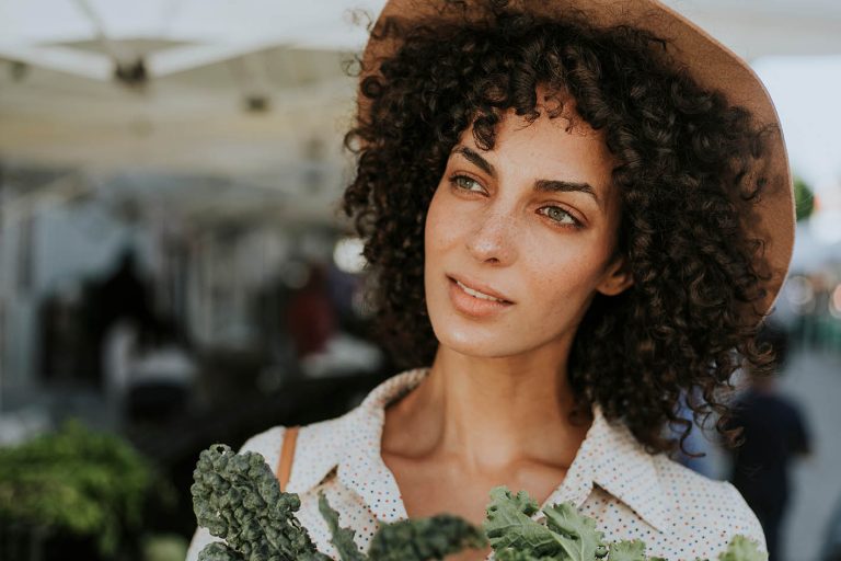 Γυναίκα αγοράζει λαχανικά πράσινα