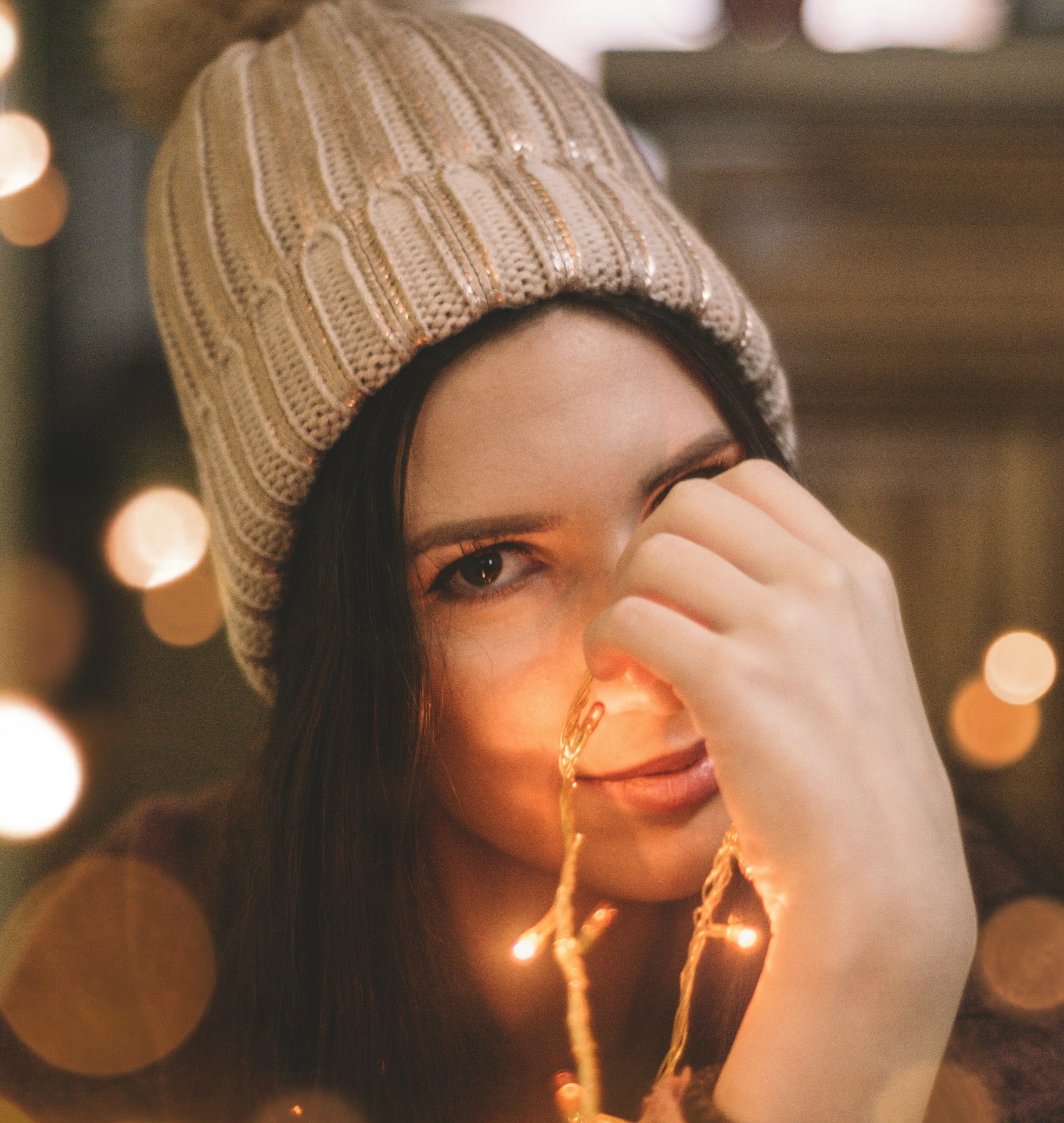 Νεαρή γυναίκα κρατάει λαμπάκια χριστουγεννιάτικα