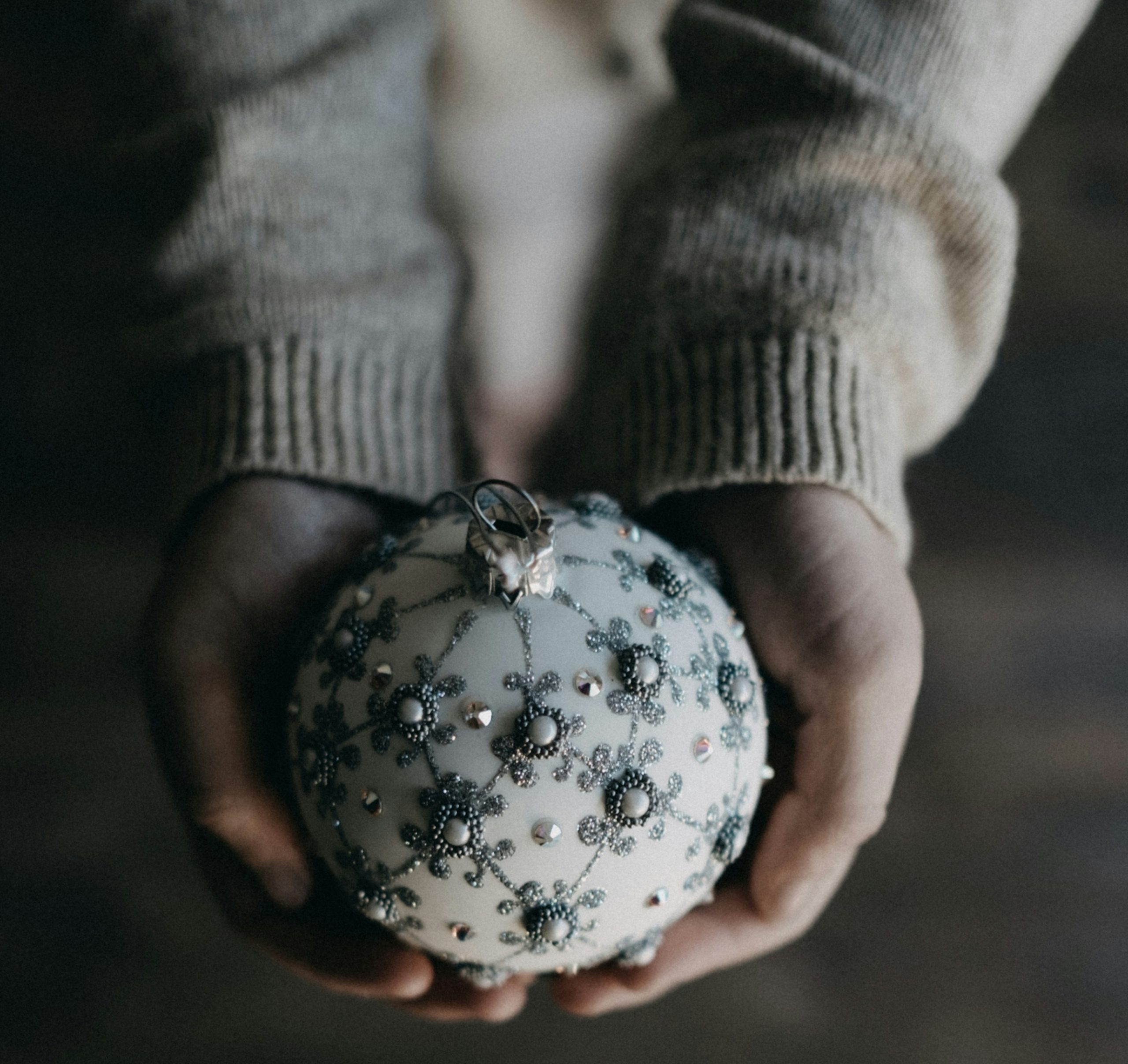 Γυναίκα κρατάει μία χριστουγεννιάτικη μπάλα