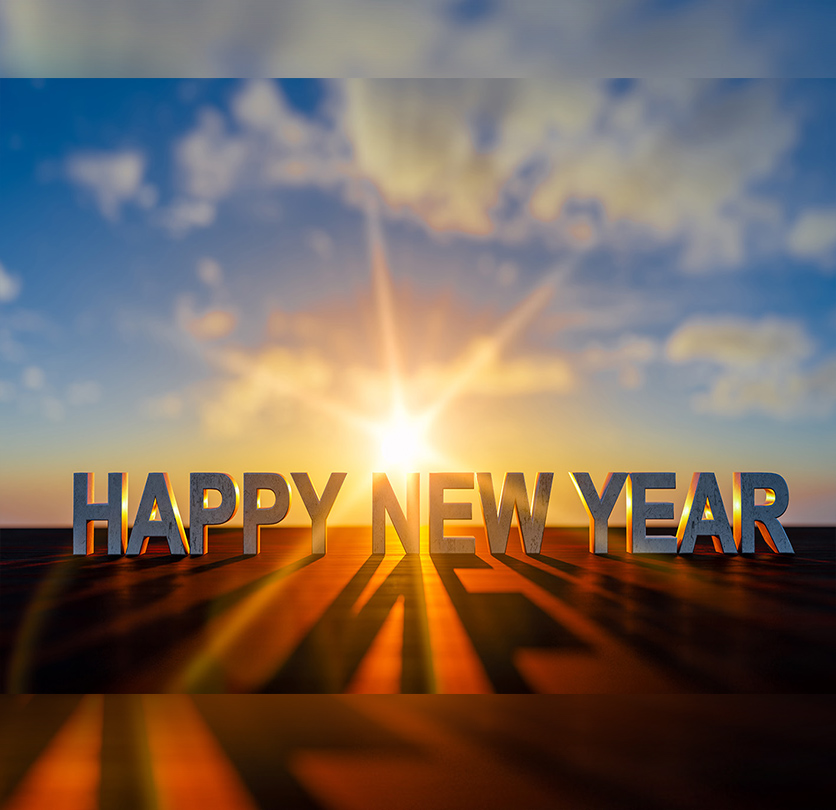 Ευτυχισμένη Νέα Χρονιά διαβάζουμε την ώρα που η φωτογραφία δείχνει έναν ήλιο να δύει.