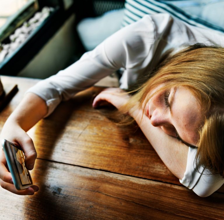 Γυναίκα κοιτάζει λυπημένη το κινητό της