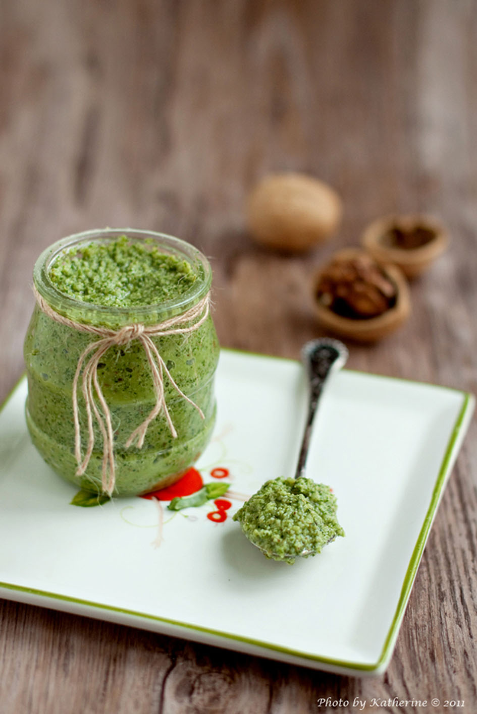 Πέστο σε γυάλινο μπολ με μια γεμάτη κουταλιά με πέστο ακουμπισμένη στο πλάι