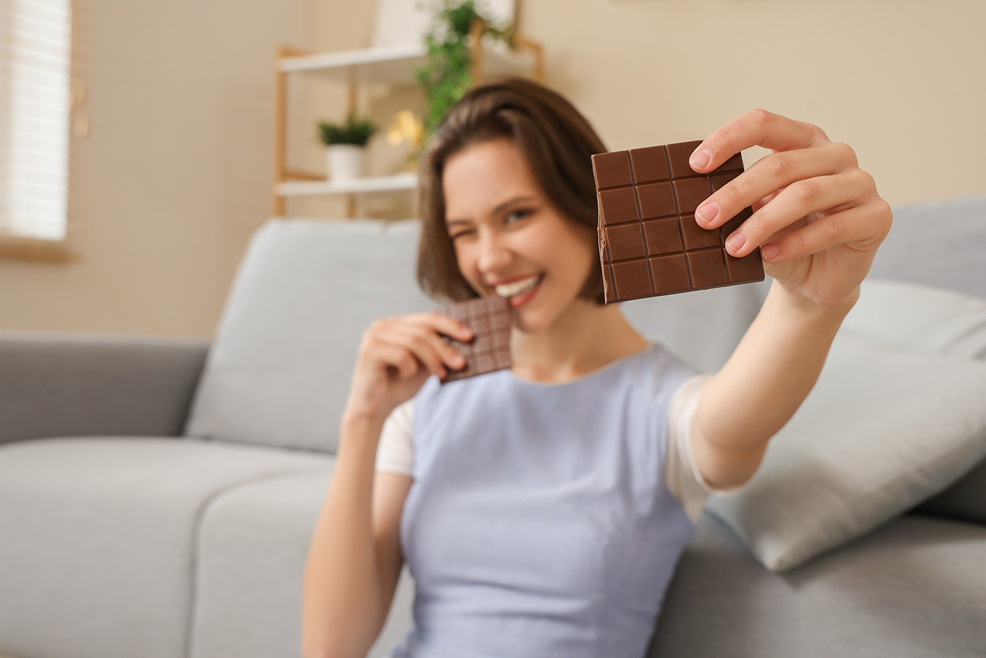 Γυναίκα χαμογελά τρώγοντας σοκολάτα