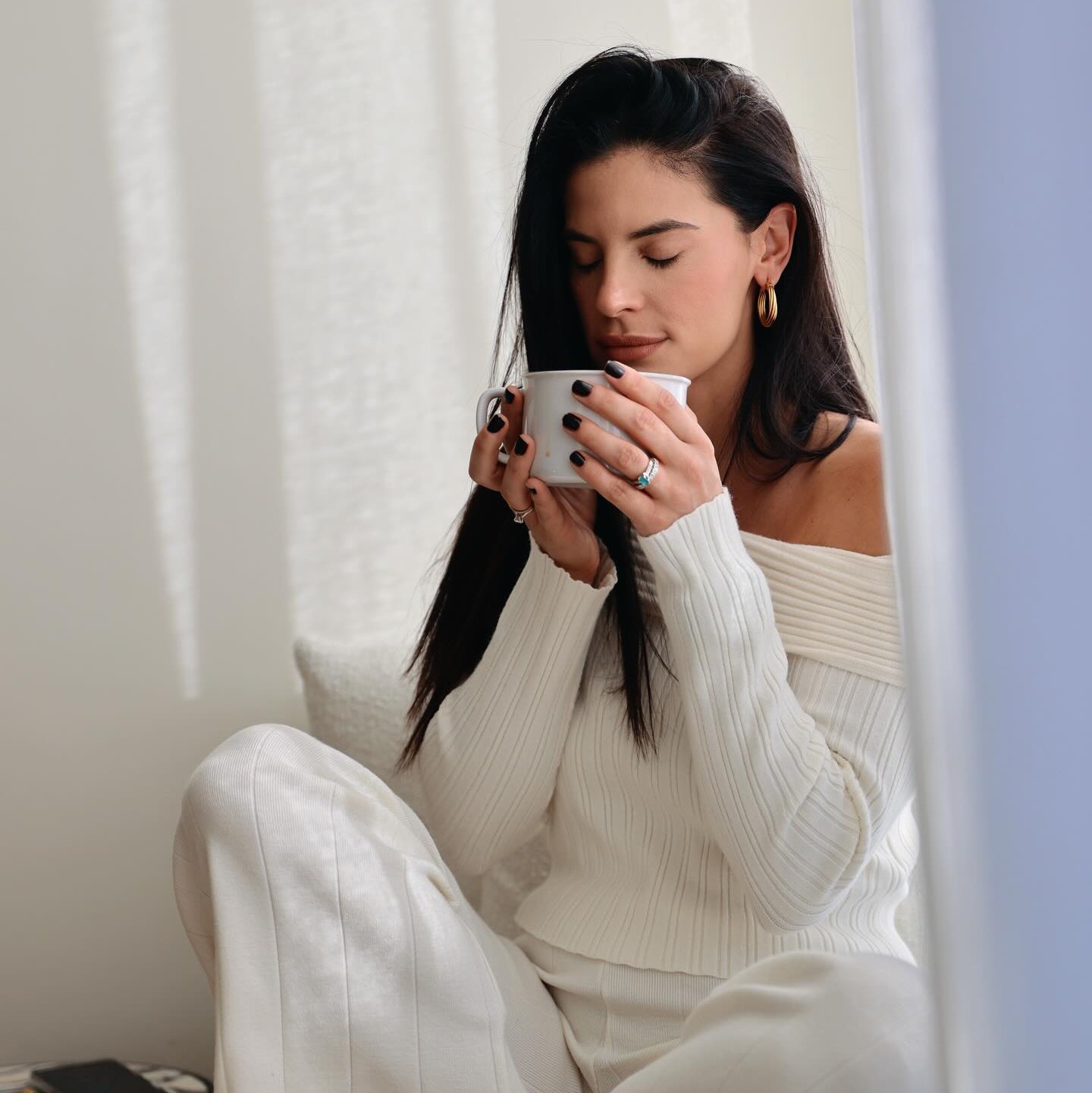 Η Χριστίνα Μπόμπα πίνει καφέ με λευκά ζεστά ρούχα