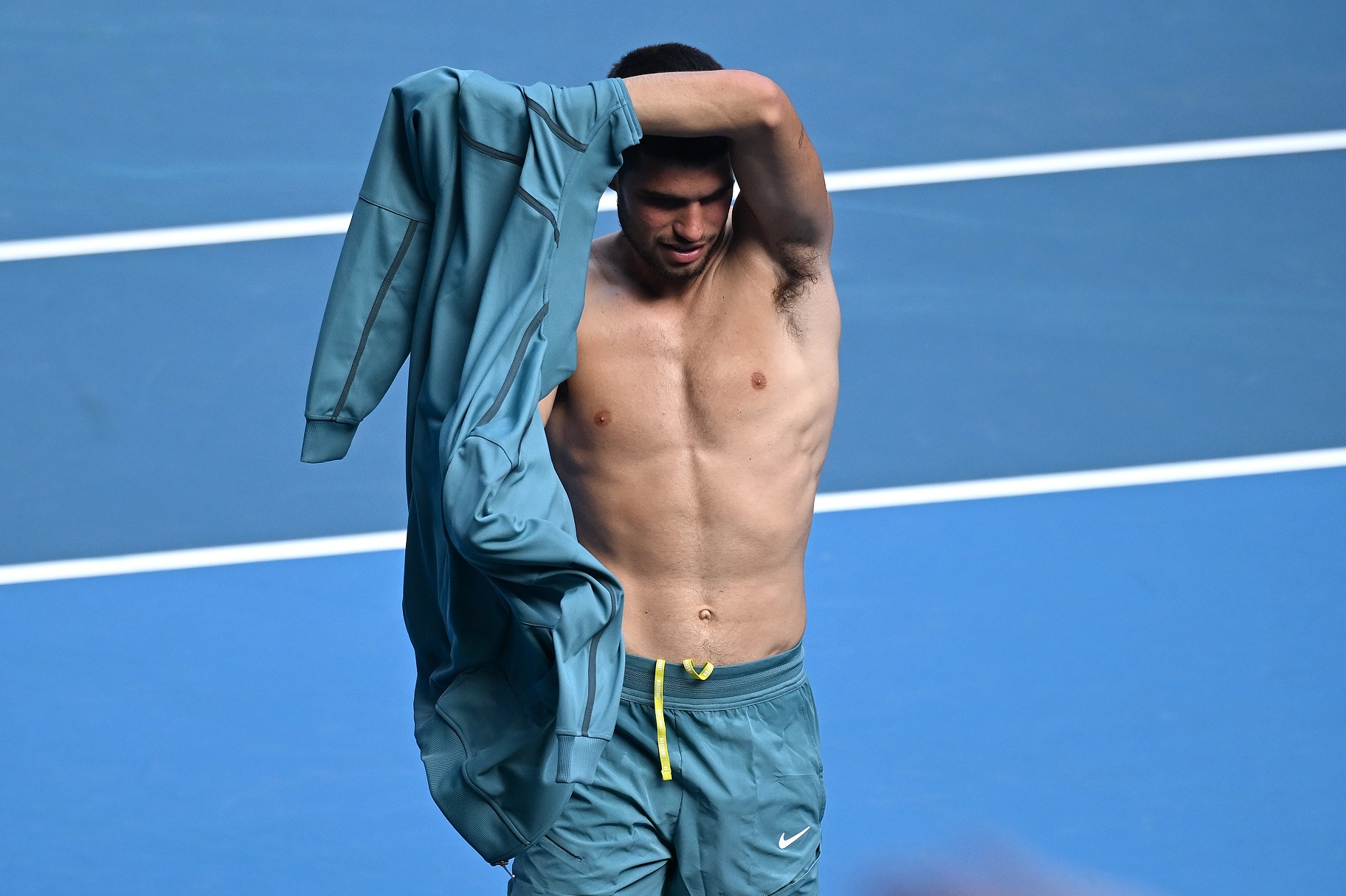 Ο Ισπανός τενίστας Carlos Alcaraz αλλάζει μπλούζα μετά τη νίκη του στον τέταρτο γύρο εναντίον του Jack Draper από τη Μεγάλη Βρετανία στο Australian Open στη Μελβούρνη, στις 19 Ιανουαρίου 2025.