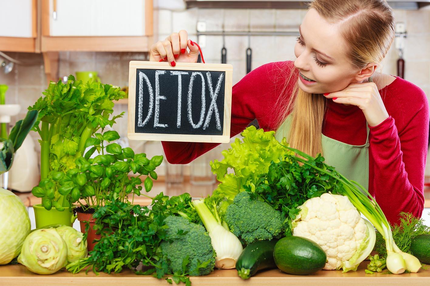Γυναίκα με πράσινα λαχανικά και με τη λέξη Detox-Αποτοξίνωση σε πινακάκι