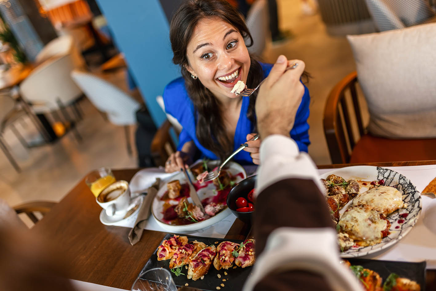 Γυναίκα σε τραπέζι τρώει χαρούμενη