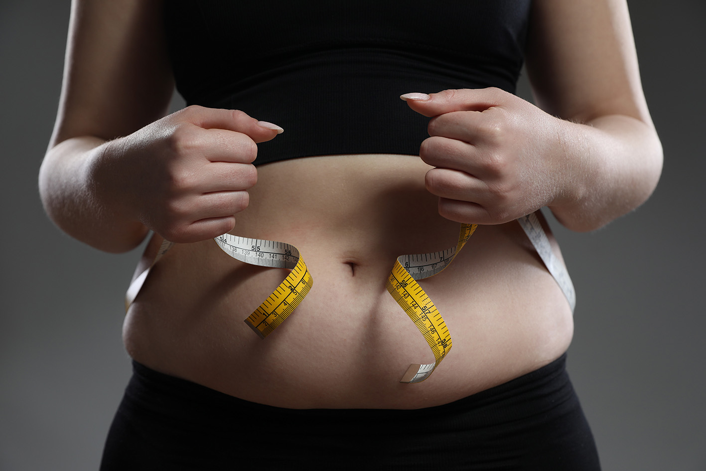 Γυναίκα μετρά με μεζούρα την κοιλιά της