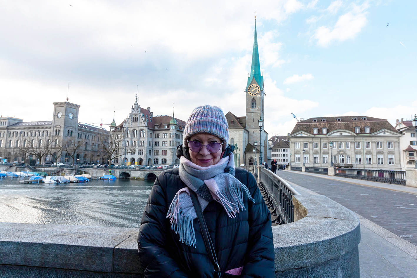 Γυναίκα τουρίστρια, κατά τη διάρκεια της χειμερινής τουριστικής περιόδου, ποζάρει σε γέφυρα της Ζυρίχης, πάνω από τον ποταμό Limmat.