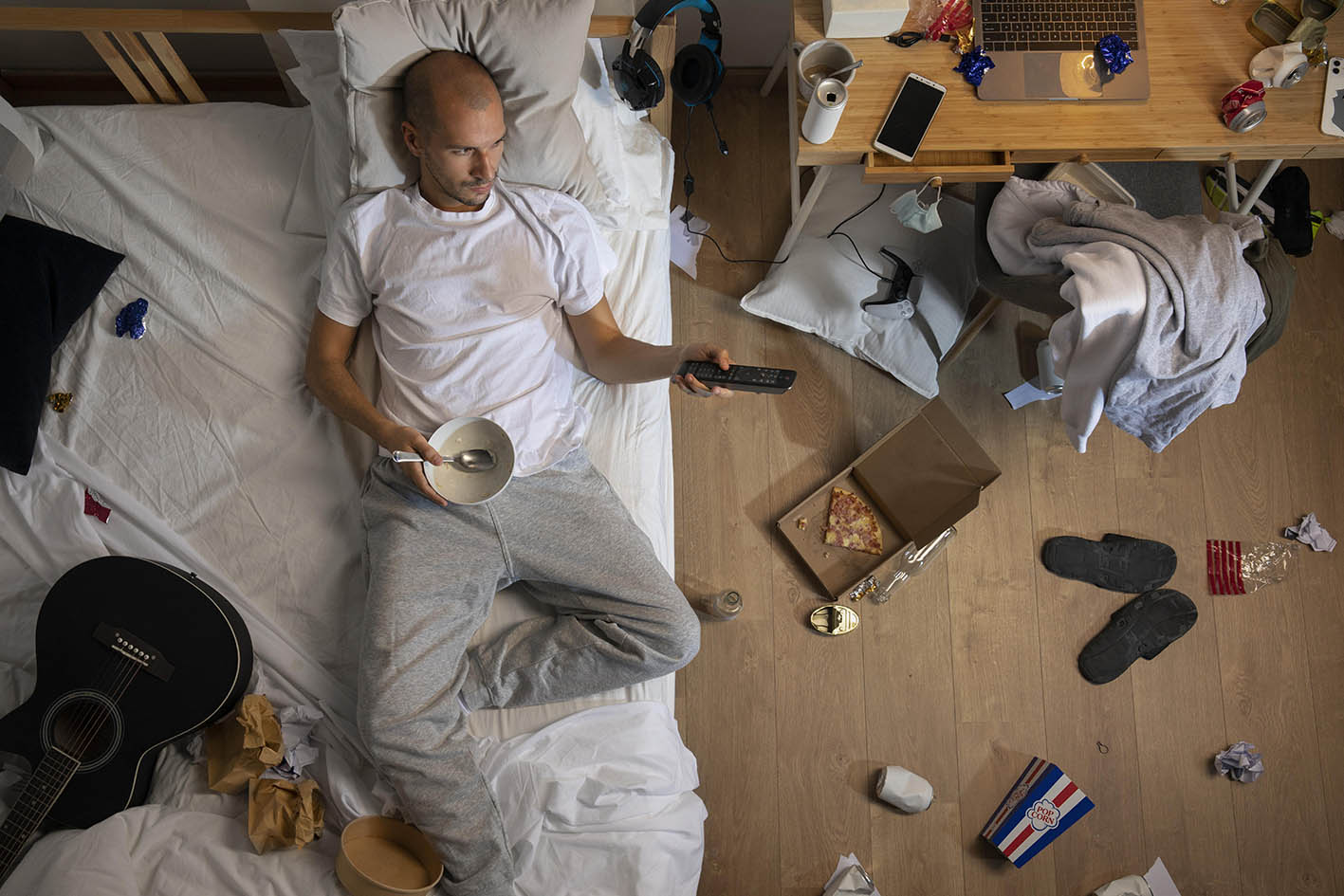 Άνδρας ξαπλωμένος σε κρεβάτι σε μία ακατάστατη και βρώμικη κρεβατοκάμαρα