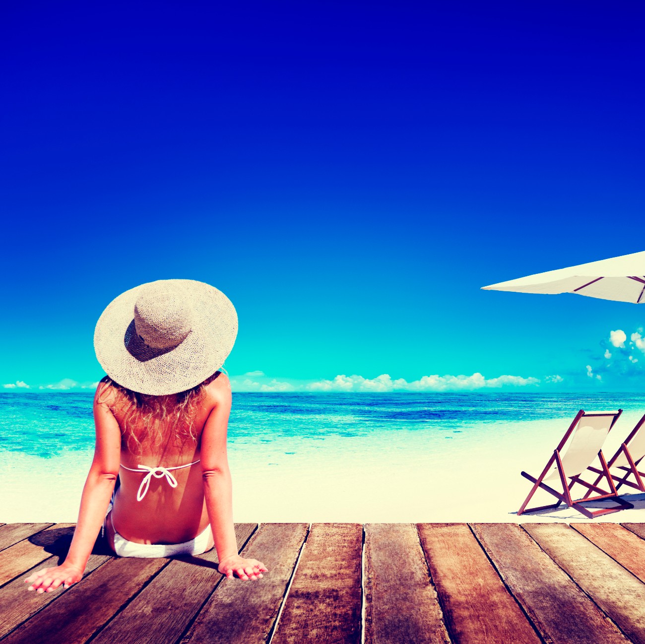 Γυναίκα κάνει μπάνιο στην παραλία και ηλιοθεραπεία φορώντας καπέλο