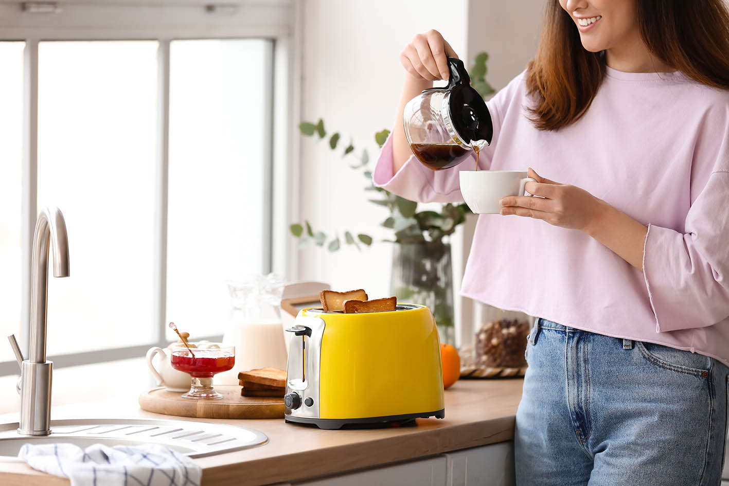 Γυναίκα ετοιμάζει πρωινό και σερβίρει καφέ