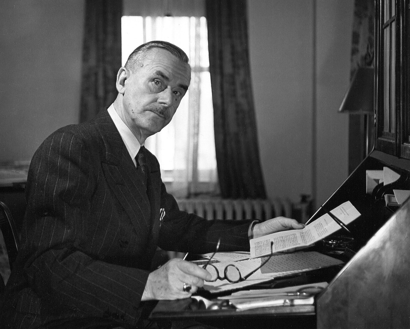 Πορτρέτο του Γερμανού συγγραφέα Thomas Mann (1875 - 1955) καθώς κάθεται στο γραφείο του, με ένα κομμάτι χαρτί στο ένα χέρι και τα γυαλιά του στο άλλο, Νέα Υόρκη, 1943.