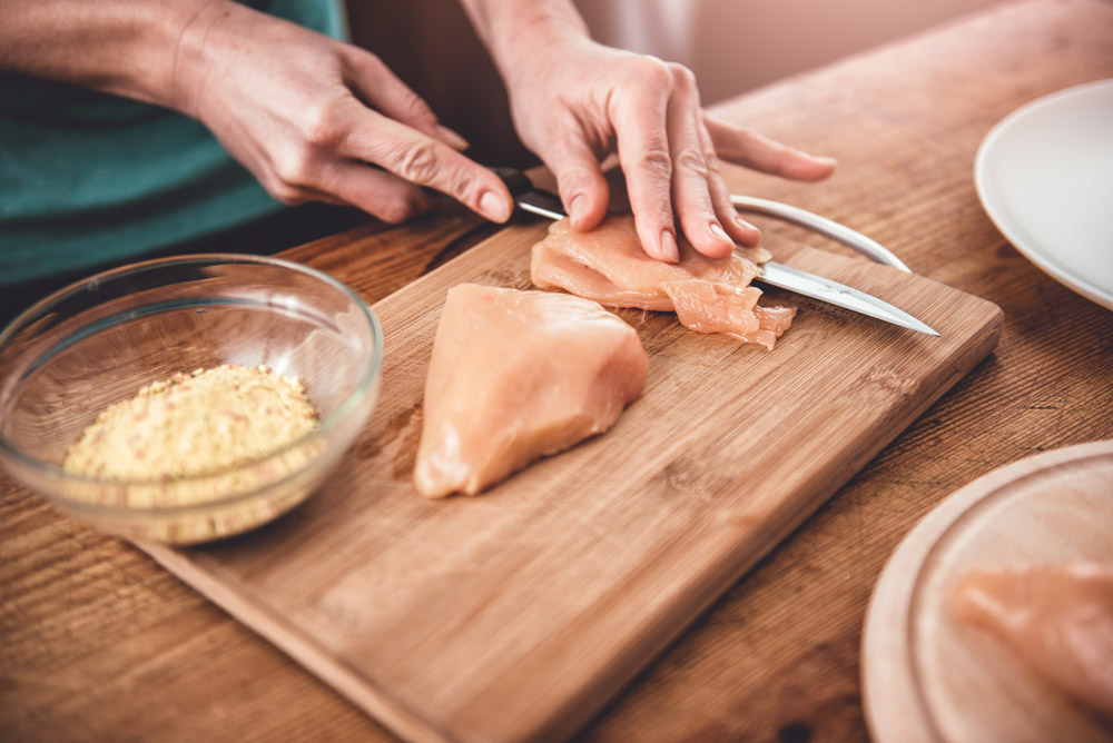 Γυναίκα κόβει κοτόπουλο