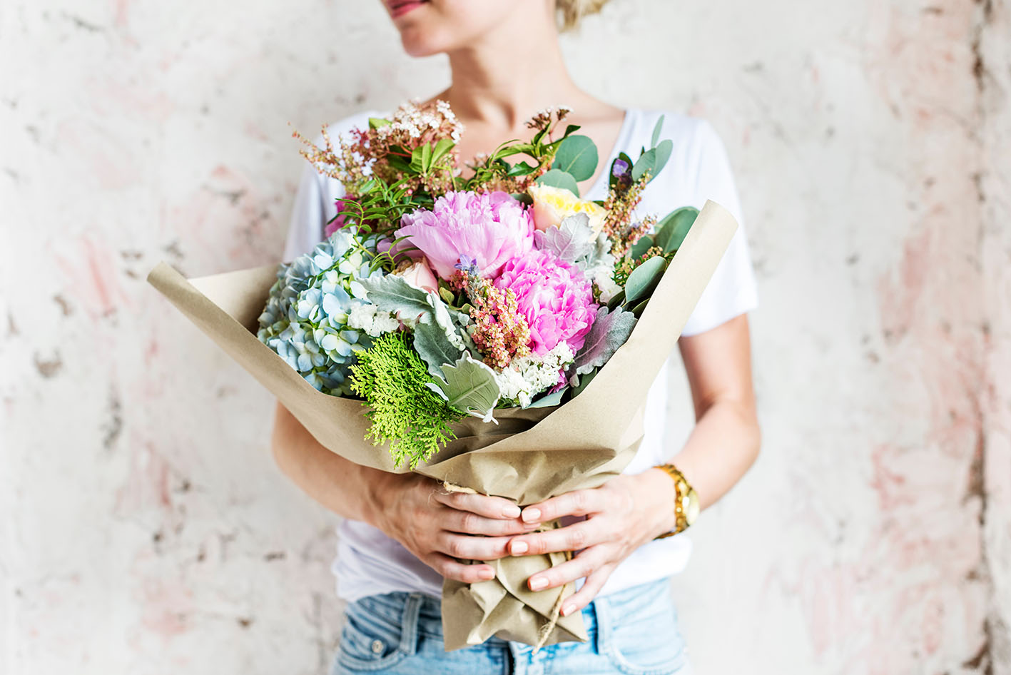 Γυναίκα με αγκαλιά λουλούδια σε μπουκέτο