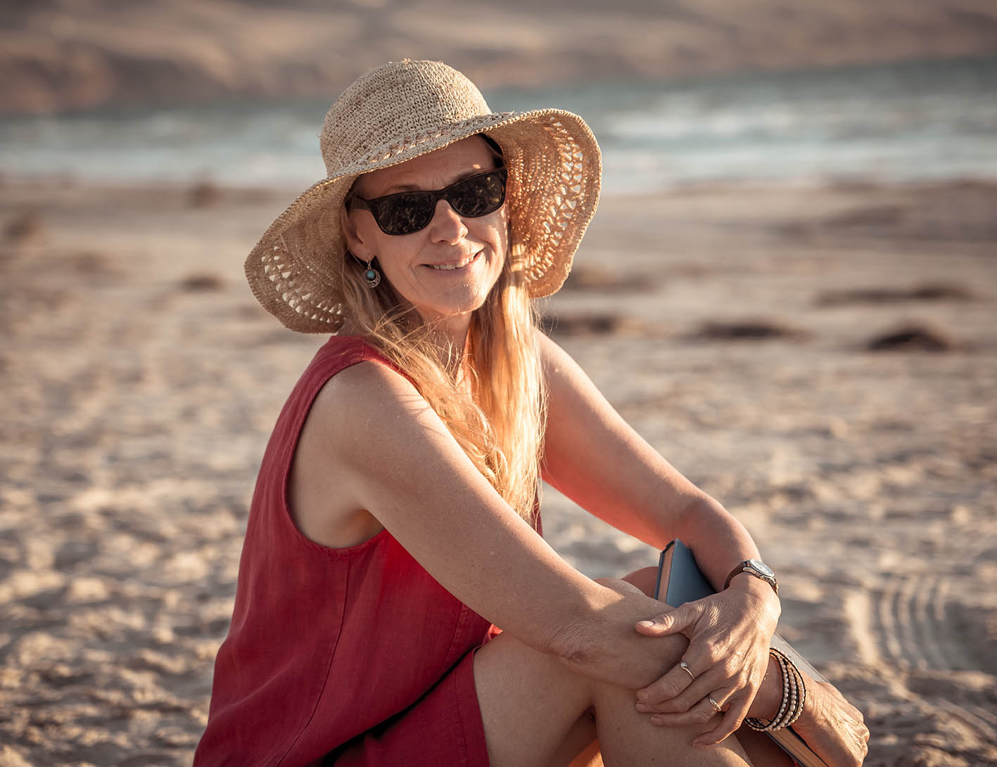 Γυναίκα με καπέλο στην παραλία