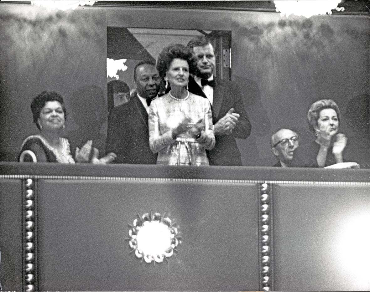 Η Rose Kennedy στον κέντρο της φωτογραφίας με τον γιο της γερουσιαστή Edward M 'Ted' Kennedy στην παράσταση «Λειτουργία» του Λέοναρντ Μπερνστάιν. Η συγκεκριμένη παράσταση ήταν η εναρκτήρια στο Κέντρο Παραστατικών Τεχνών John F Kennedy Center στην Ουάσινγκτον, στις 8 Σεπτεμβρίου 1971. Μαζί τους στα αριστερά η σύζυγος του δημάρχου της Νέας Υόρκης Bennetta Bullock Washington με τον δήμαρχο Walter Washington λίγο πιο πίσω.