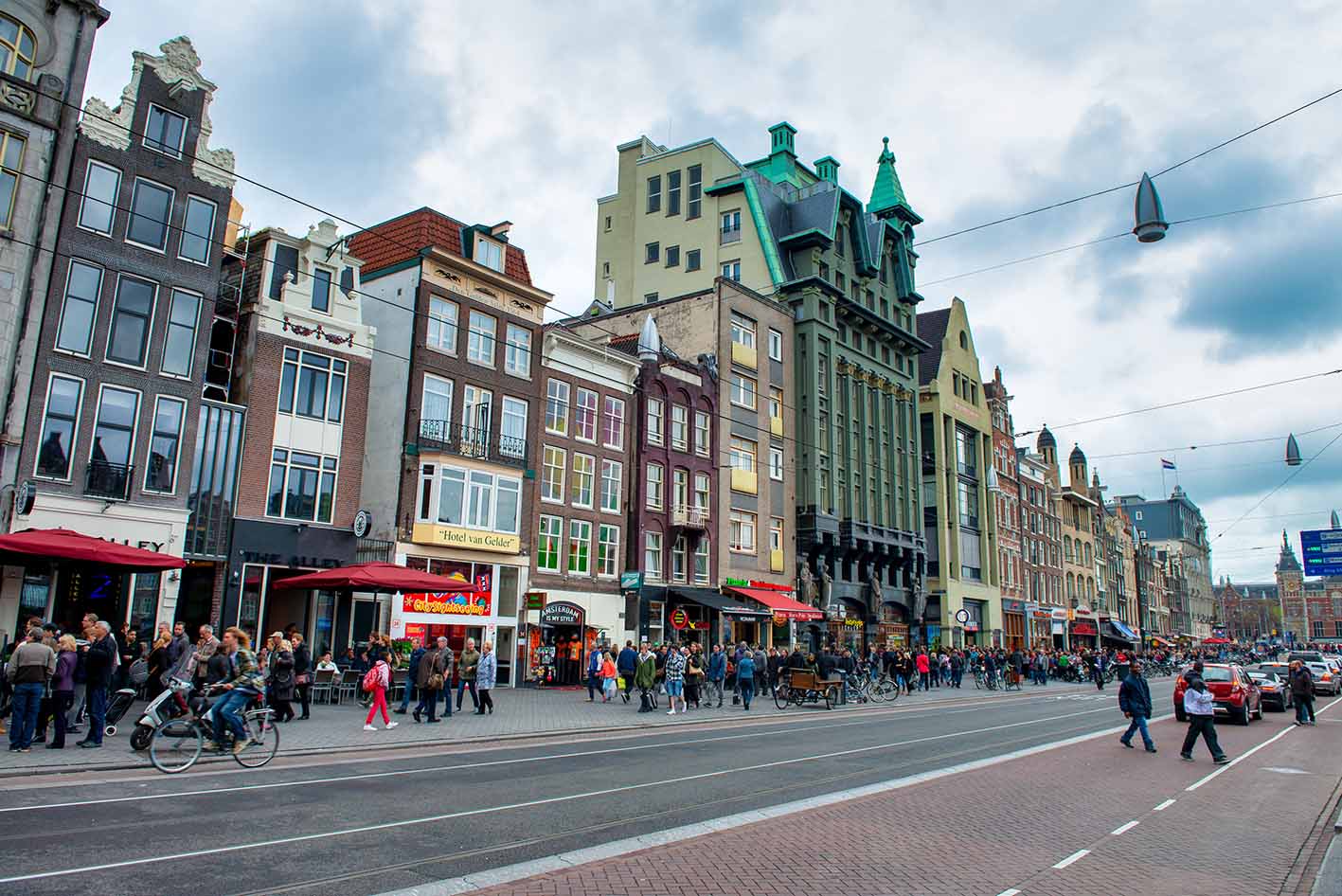 Τουρίστες και ντόπιοι περπατούν στο Άμστερνταμ.