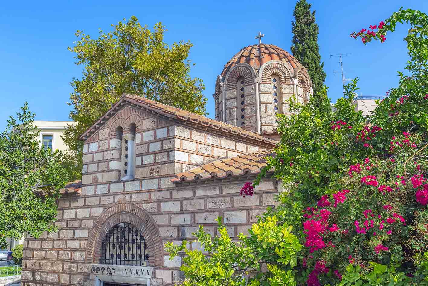 Μικρό βυζαντινό παρεκκλήσι στην περιοχή της Πλάκας της ελληνικής πρωτεύουσας και λουλούδια στην Αθήνα, Ελλάδα