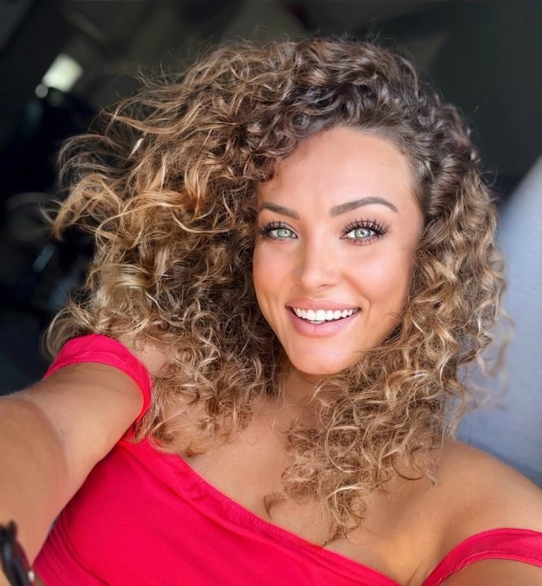 Καστανόξανθη χαμογελαστή κοπέλα με καλοσχηματισμένες μπούκλες