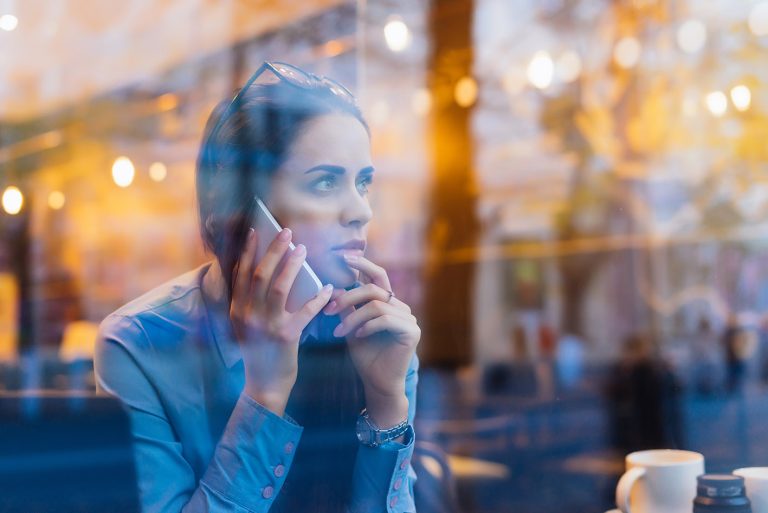 Γυναίκα νέα σε καφέ μιλα στο τηλέφωνο